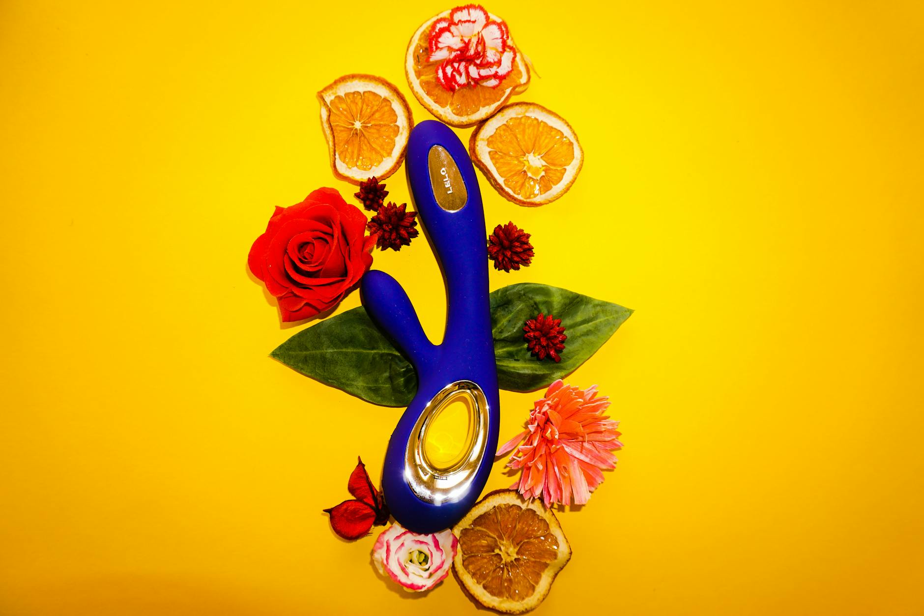 Close-up of hands holding a sleek blue lemon clitoral vibrator against a purple background