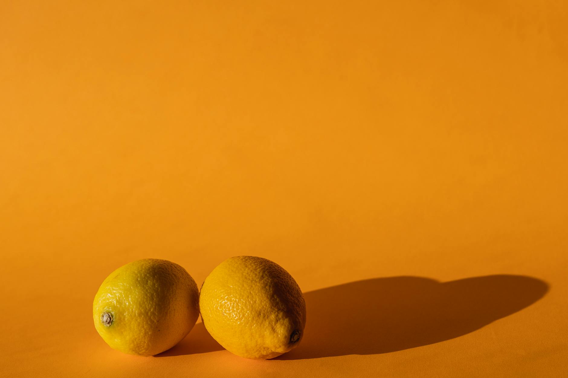Ripe vivid lemons composed on a bright yellow background