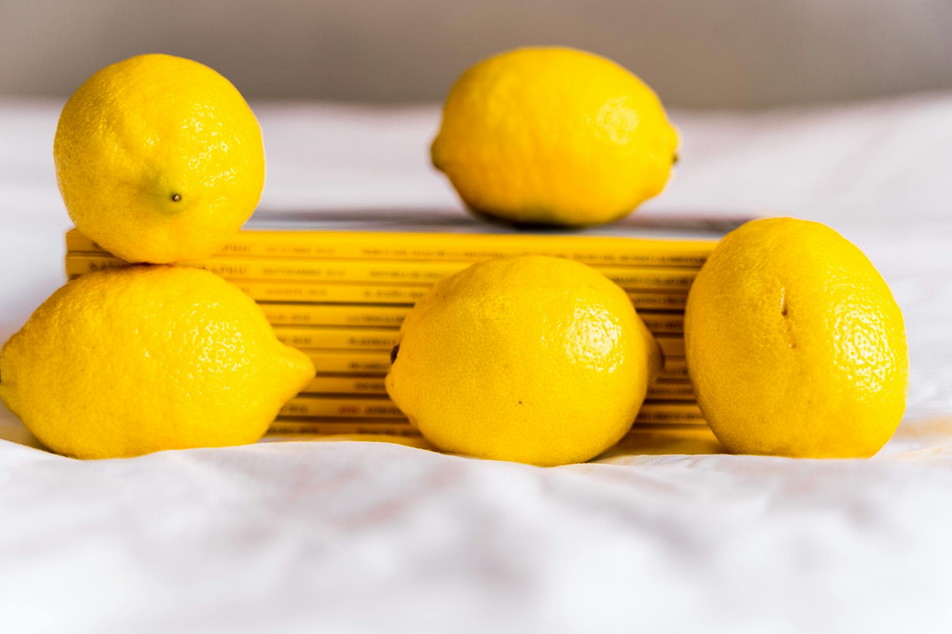 Hand holding a lemon-yellow vibrator against a minimalist backdrop, showing modern design and texture